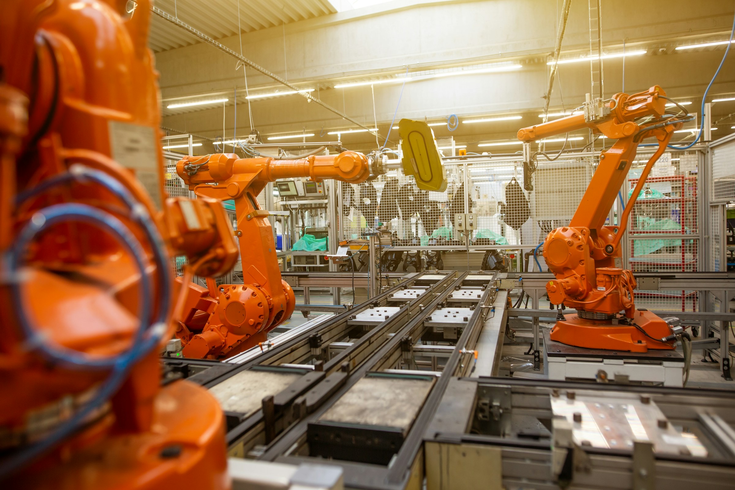 Industrial robot cells operating across an automated production line