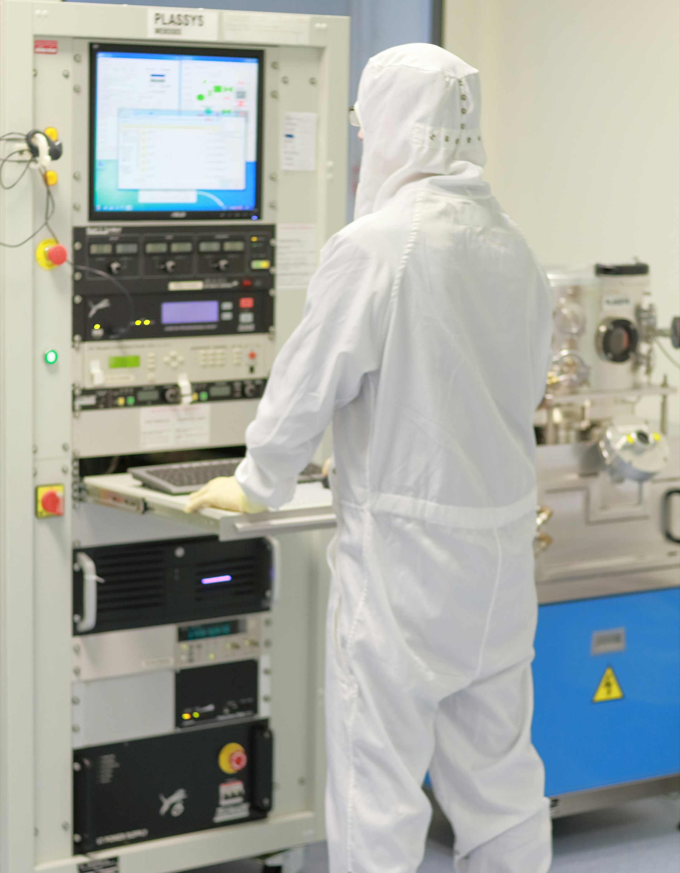 Semiconductor engineer operating process equipment in a cleanroom