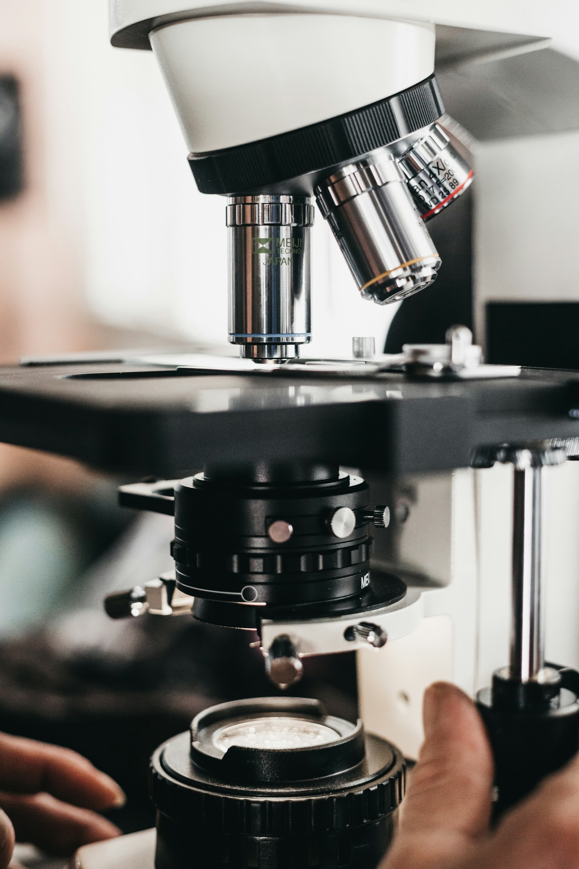 Researcher adjusting a microscope for detailed systems validation