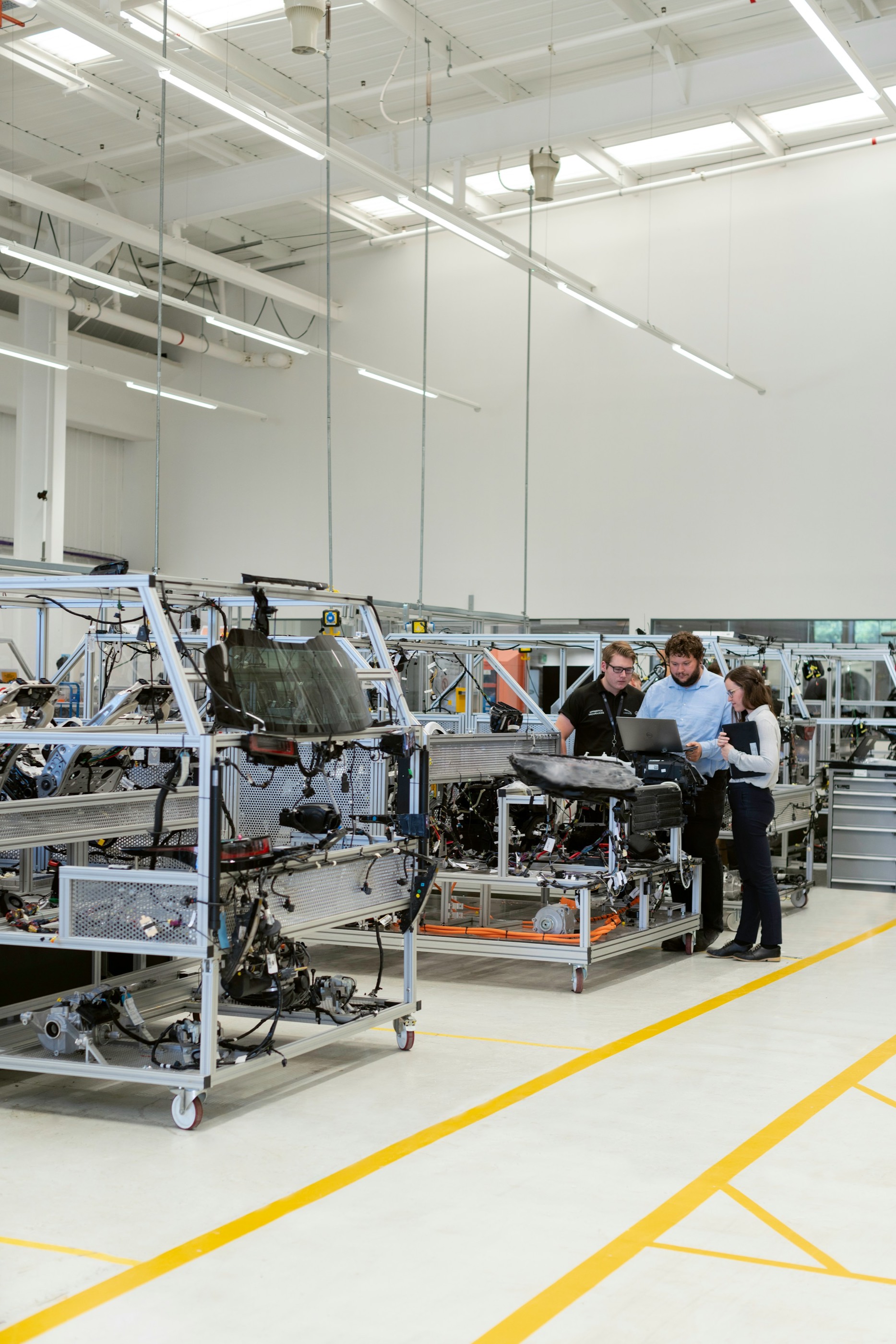 Engineering team reviewing an integrated vehicle system on a factory floor